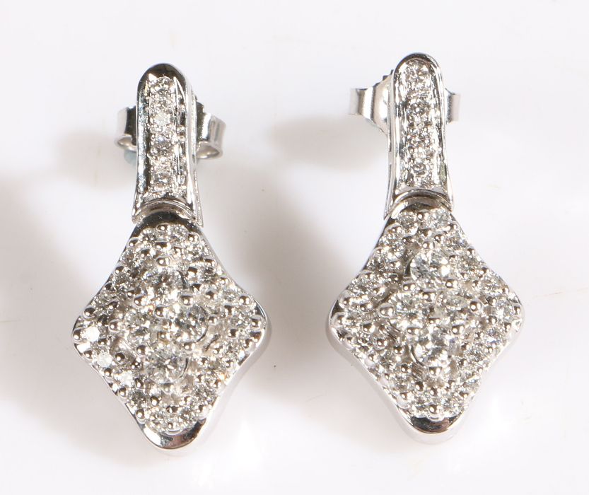 A pair of 14 carat white gold and diamond earrings, the diamonds arranged in the form of a