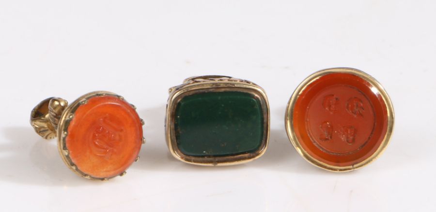 A set of three antique fob seals, each intricately engraved with scroll and foliate design and gem- - Image 2 of 2