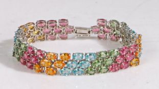 A 9 carat white gold and multi coloured sapphire bracelet, the colours ranging from blue, yellow,