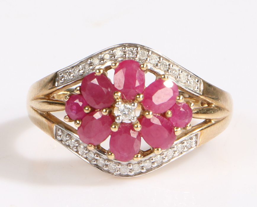 A modern 9 carat gold ruby and diamond cluster ring, the flowerhead comprised of six oval cut rubies