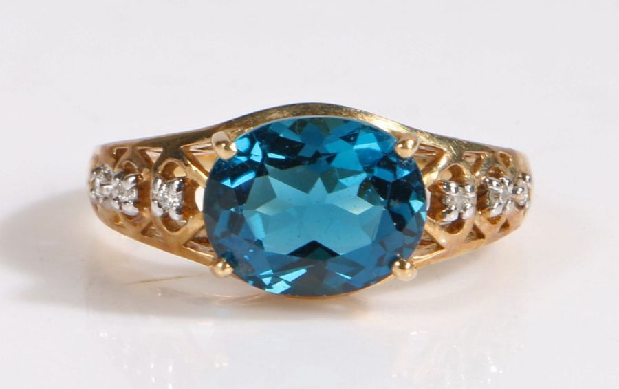 A 9 carat gold London blue topaz and diamond ring, the head set with a claw mounted oval cut