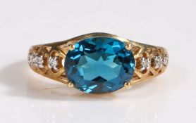 A 9 carat gold London blue topaz and diamond ring, the head set with a claw mounted oval cut