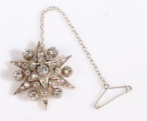 An Edwardian diamond brooch in the form of star, set with many diamonds, the central diamond