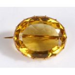 A 9 carat gold and yellow stone set brooch, of oval form and facetted edge, 23 x 19mm, 6.20 grams.