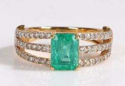 A 18 carat gold emerald and diamond ring, the heads set with a claw mounted baguette cut emerald