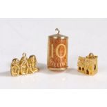 A collection of of three 9 carat gold charms, comprised of 'three wise monkeys', a stanhope church