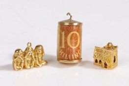 A collection of of three 9 carat gold charms, comprised of 'three wise monkeys', a stanhope church