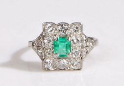 Platinum emerald and diamond cluster ring, possibly Edwardian. The central emerald is framed by