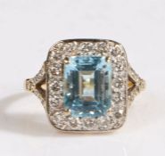 A 18 carat gold diamond and aquamarine ring, the head set with a baguette cut aquamarine stone