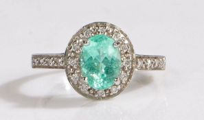 A 18 carat white gold paraiba tourmaline and diamond ring, the head set with a claw mounted oval cut