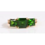 A 9 carat gold and green stone ring, the head set with three square cut green stones, ring size O