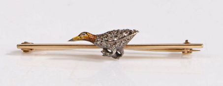 A yellow metal bar brooch decorated with a bird, the body of the bird decorated with diamonds and