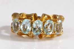 A 18 carat gold and aquamarine kutchisky style ring, with two rows of bamboo affect rings set with