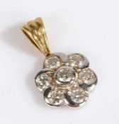 An 18 carat gold and diamond pendant in the form of a flower head set with seven brilliant cut