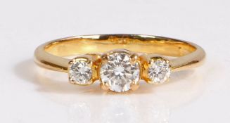 A yellow metal and diamond set ring, the head set with three brilliant cut diamonds, diamonds