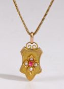 An antique locket formed of an elegant plaque with raised floral motif, set with pearls and a red