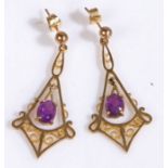 A pair of gold and amethyst pendant earrings, each having an oval cut amethyst pendant suspended