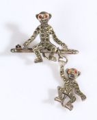 A sterling silver Edwardian novelty monkey brooch, featuring one monkey sat on a pole with a further