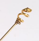 An elegant yellow metal serpent pin, having spiralled carving to the stem is surmounted by a