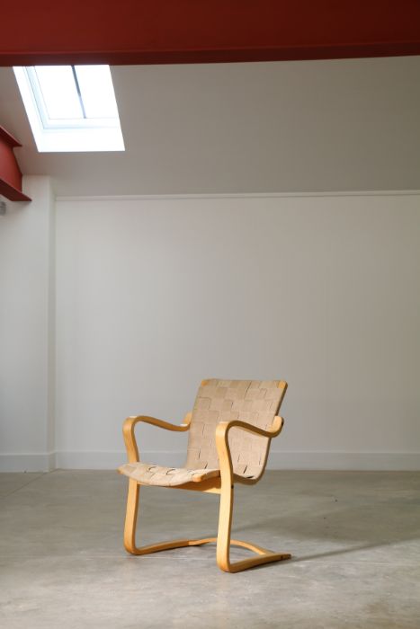 A Swedish formed laminate & canvas armchair by Gustav Aksel Berg for Broderna Andersson, stamped,