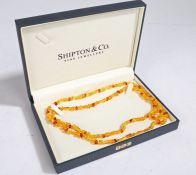 An amber necklace, comprised of small amber pieces accented by larger oval amber beads, measuring