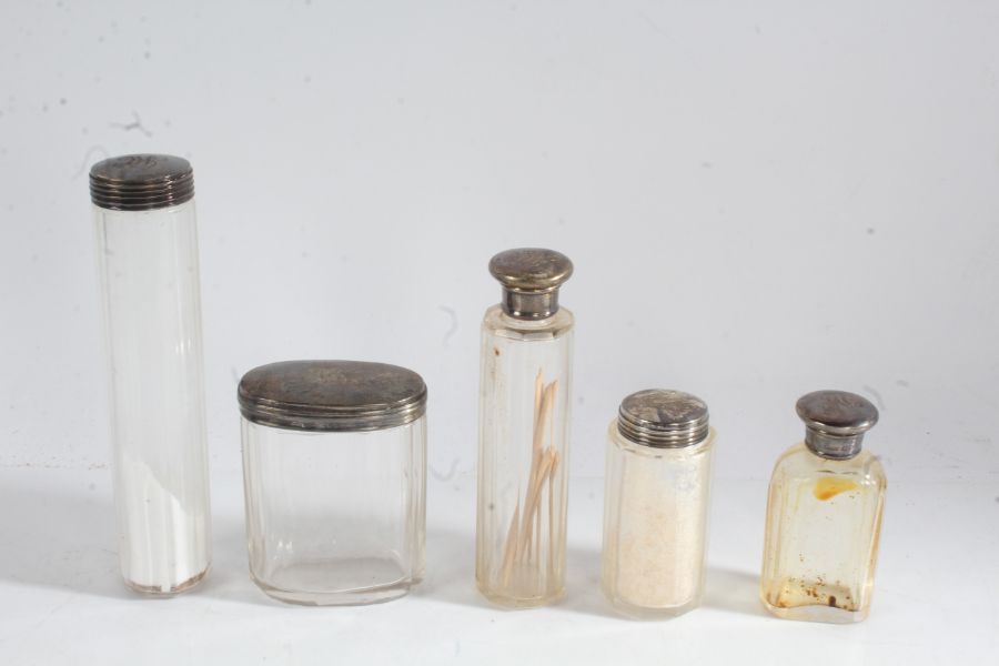 Five silver lidded clear glass dressing table bottles and pots, all initialled MC (5)