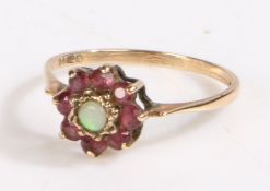 9 carat gold Opal and garnet ring, the head in the form of a flower with a central cabochon cut Opal