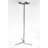 Iron trivet, the pierced circular top raised on a plain stem and tripod feet, 83cm high