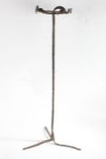 Iron trivet, the pierced circular top raised on a plain stem and tripod feet, 83cm high