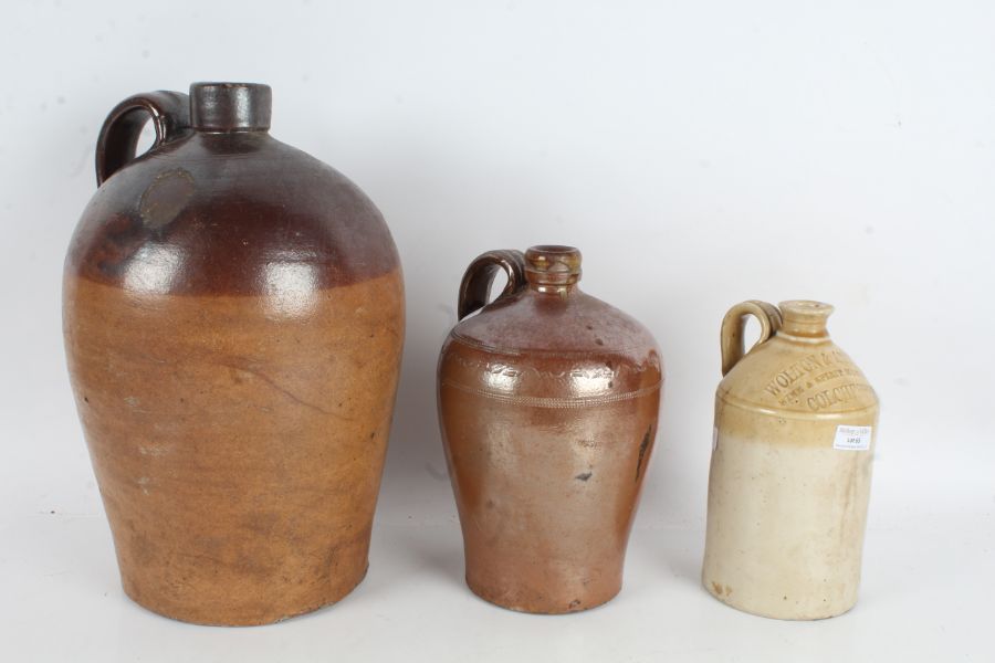 Three stoneware jugs, one marked Wolton & Attwood Colchester, the largest 36cm high