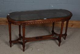 20th century mahogany coffee table, with a cane and glass top set on a carved frieze and reeded