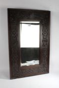 A Gothic revival rectangular oak wall mirror, with a Gothic design boarder and a rectangular beveled