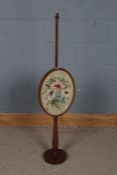 Edwardian mahogany and needlework fire screen, the oval needlework screen depicting flowers together