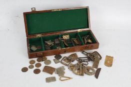 Collection of various metal buckles and tokens housed within a wooden box (Qty)