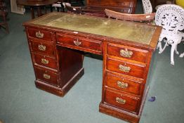 A 20th century mahogany leather topped desk, with a green leather and gilt tooled top above nine