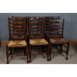 Six oak ladder back dining chairs, all with rush seats, largest 100cm high