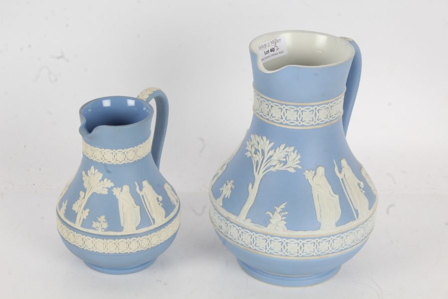 Two Wedgwood blue jasperware jugs, both depicting classical scenes with acanthus leaf decoration