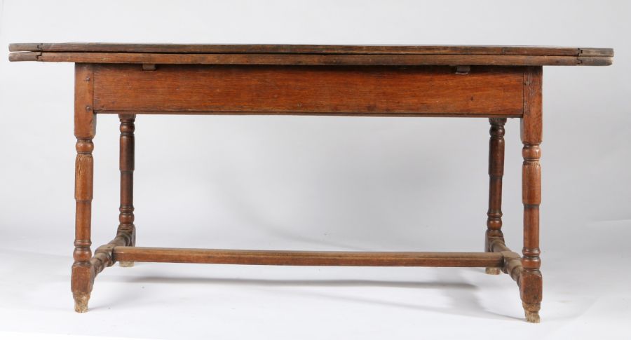 An early 18th century oak draw-leaf table, French, circa 1730 Having a triple boarded and end-