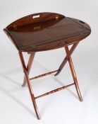 George III mahogany butlers tray, with hinged folding sides, raised on a folding stem with turned