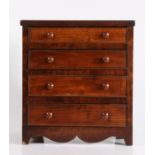 19th Century mahogany miniature chest of four long drawers, with reeded frieze and shaped apron,
