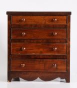 19th Century mahogany miniature chest of four long drawers, with reeded frieze and shaped apron,