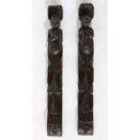 Pair of carved oak figural terms, depicting two figures holding a fish and a bunch of grapes, with