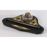 Ebonised and brass mounted desk stand, with a brass capped glass inkwell and pen rest, 32cm wide
