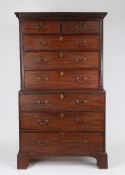 George III mahogany chest on chest, having a dentil carved swept pediment above two short and