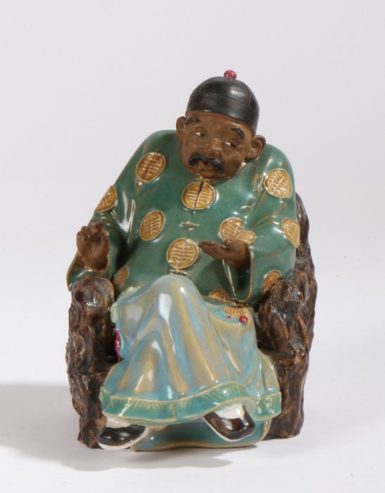 20th Century Chinese porcelain figure depicting a gentleman seated in a naturalistically modelled