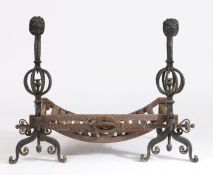 Unusual pair of cast iron fire dogs, the lions head terminals above pierced rope twist orb form