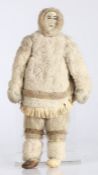 Inuit figural doll, the marine ivory carved head with carved features, with fur jacket, reindeer