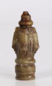 Oriental jade carving, the stepped top section with hole above four carved masks and turned