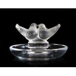 A Lalique ring tray, of circular form surmounted by twin doves, etched mark to base, 9cm diameter