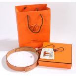 A Hermes tan leather Constance belt with panished silvered H buckle in cloth bag, belt 100cm length,